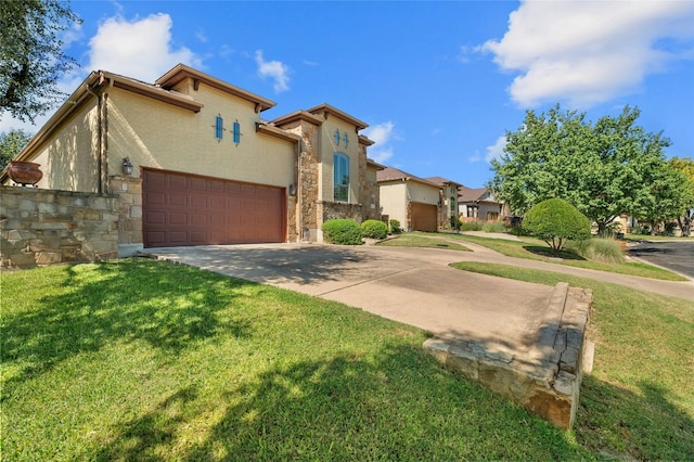 mediterranean / spanish home featuring an attached garage, stone siding, stucco siding, concrete driveway, and a front lawn