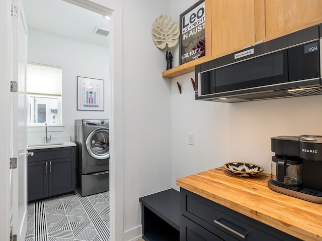 clothes washing area with sink and washer / clothes dryer