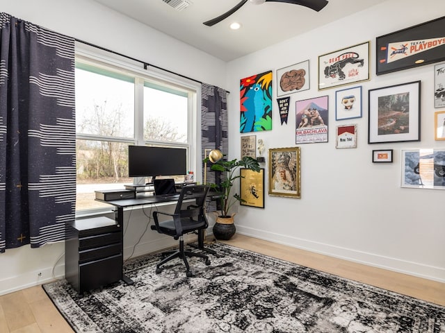 home office with light wood-type flooring and ceiling fan