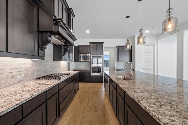 2324 Bel Paese Bnd, Leander, TX 78641 - kitchen with appliances with stainless steel finishes, light stone countertops, decorative backsplash, light wood-style floors, and recessed lighting