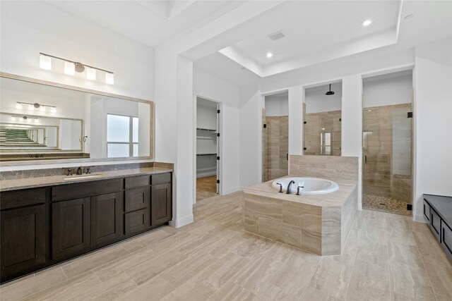 2324 Bel Paese Bnd, Leander, TX 78641 - bathroom with a tile shower, vanity, a garden tub, a tray ceiling, and recessed lighting