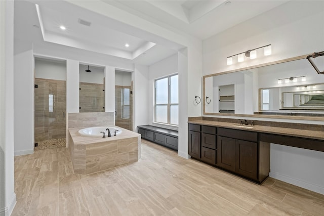 2324 Bel Paese Bnd, Leander, TX 78641 - full bathroom with a tray ceiling, a tile shower, a garden tub, vanity, and recessed lighting