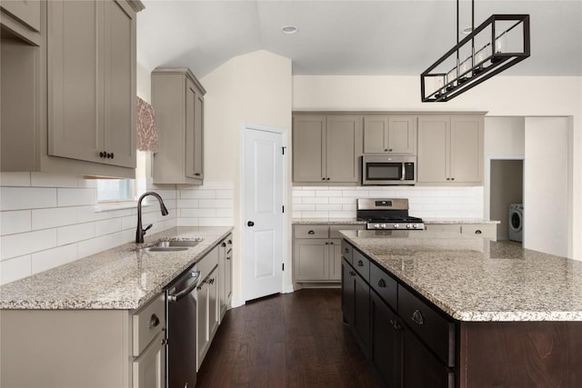 4131 Van Ness Ave, Round Rock, TX 78681 - kitchen featuring appliances with stainless steel finishes, a sink, washer / dryer, dark wood-type flooring, and decorative backsplash