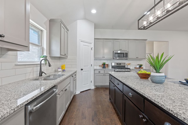 4131 Van Ness Ave, Round Rock, TX 78681 - kitchen featuring appliances with stainless steel finishes, dark wood-style floors, backsplash, light stone counters, and recessed lighting
