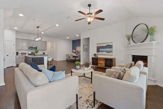 4131 Van Ness Ave, Round Rock, TX 78681 - living room featuring a ceiling fan, recessed lighting, dark wood-style floors, a lit fireplace, and vaulted ceiling