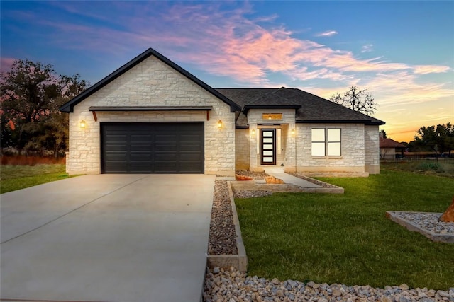 view of front of house with roof with shingles, concrete driveway, a front lawn, and an attached garage