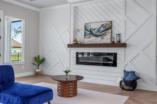 sitting room with baseboards, a healthy amount of sunlight, a glass covered fireplace, and ornamental molding