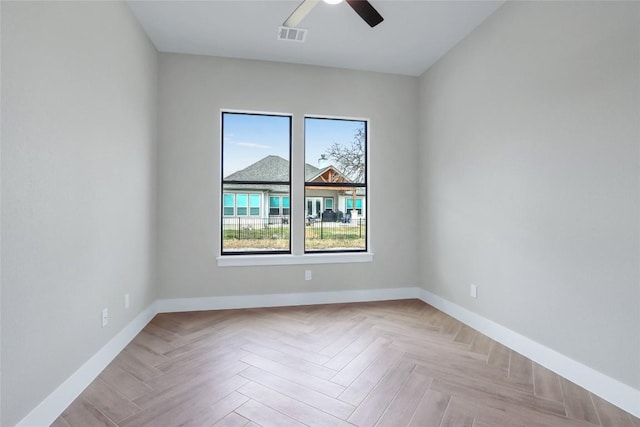 empty room with a ceiling fan, baseboards, and visible vents