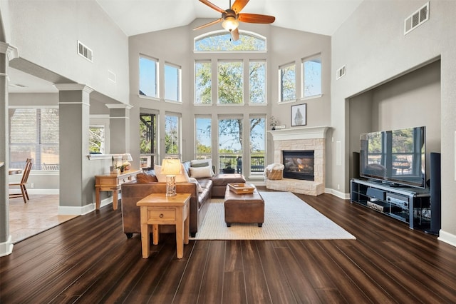 living area with visible vents, dark wood-type flooring, and ornate columns