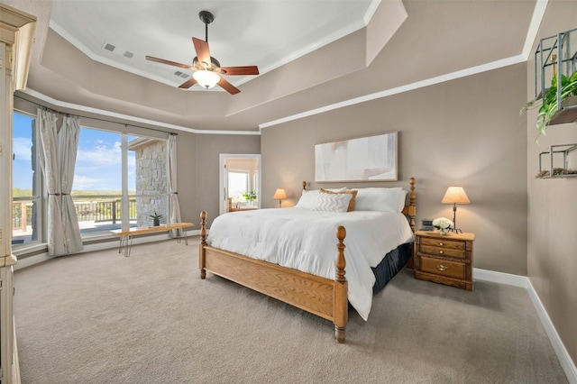 bedroom featuring crown molding, carpet, a tray ceiling, and baseboards