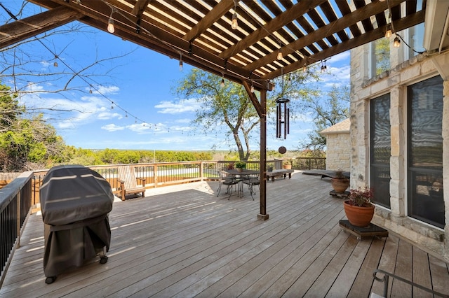 wooden deck with a grill, outdoor dining area, and a pergola