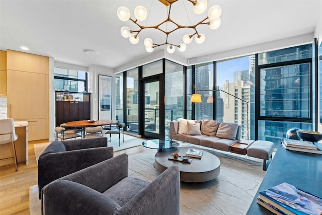 living room with a healthy amount of sunlight, an inviting chandelier, light wood-style flooring, and a view of city