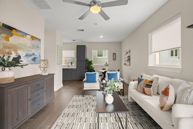 living room featuring baseboards, visible vents, wood finished floors, and recessed lighting