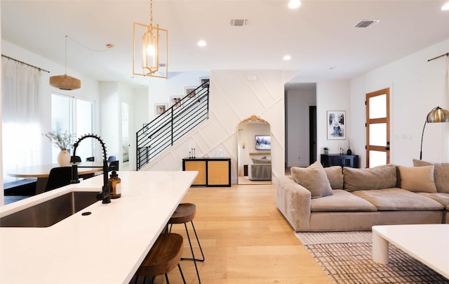 living area featuring light wood-type flooring, visible vents, recessed lighting, and stairs