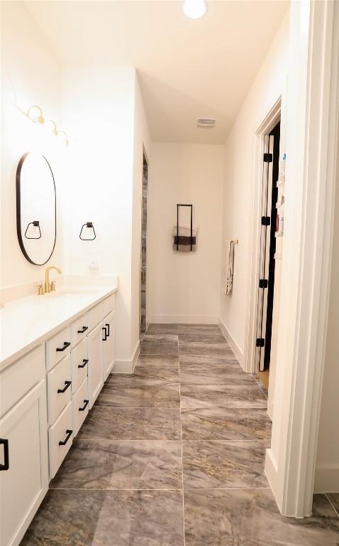 full bathroom with vanity and baseboards