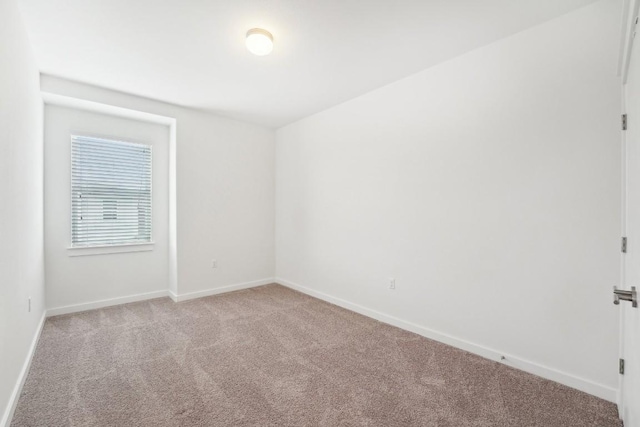 empty room with light colored carpet and baseboards