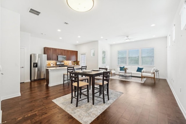 dining area with dark wood finished floors, visible vents, and recessed lighting