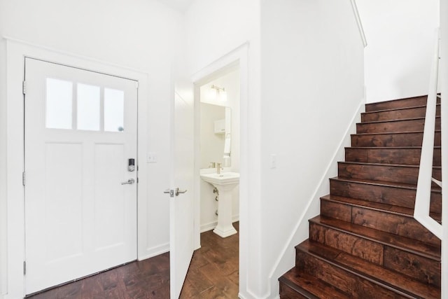 entryway with stairs, baseboards, and dark wood-type flooring