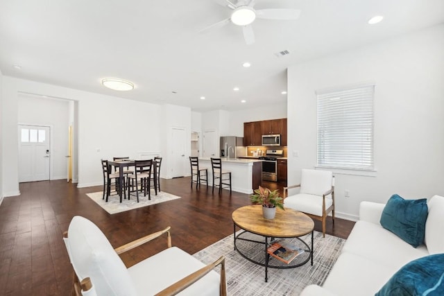 living room featuring recessed lighting, visible vents, dark wood-type flooring, a ceiling fan, and baseboards