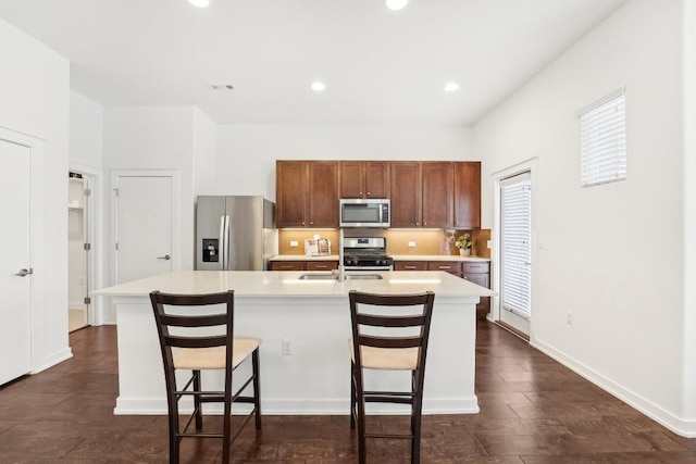 kitchen featuring light countertops, appliances with stainless steel finishes, and a kitchen island with sink