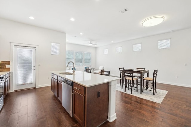 kitchen with visible vents, dishwasher, a kitchen island with sink, light countertops, and a sink