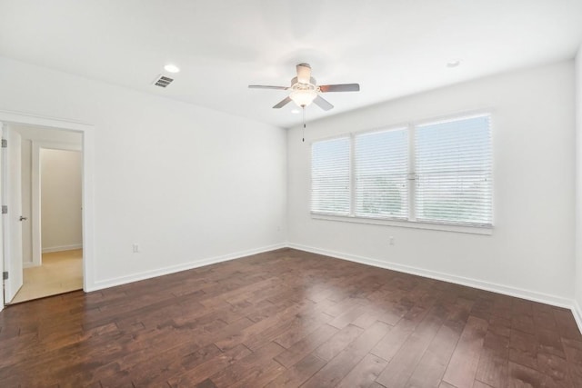 empty room featuring dark wood finished floors, recessed lighting, visible vents, ceiling fan, and baseboards