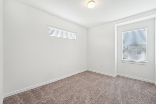 empty room with carpet and baseboards