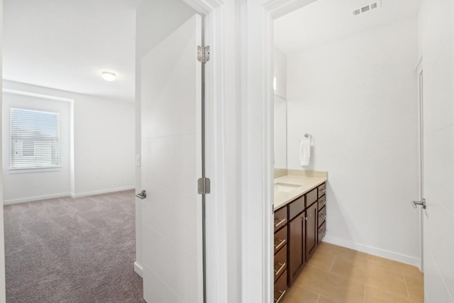 bathroom with tile patterned floors, baseboards, visible vents, and vanity