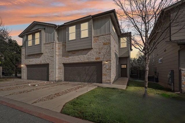 view of front of property featuring a garage, stone siding, board and batten siding, and concrete driveway