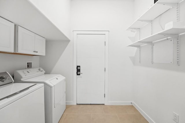 laundry room with cabinet space, independent washer and dryer, baseboards, and light tile patterned floors