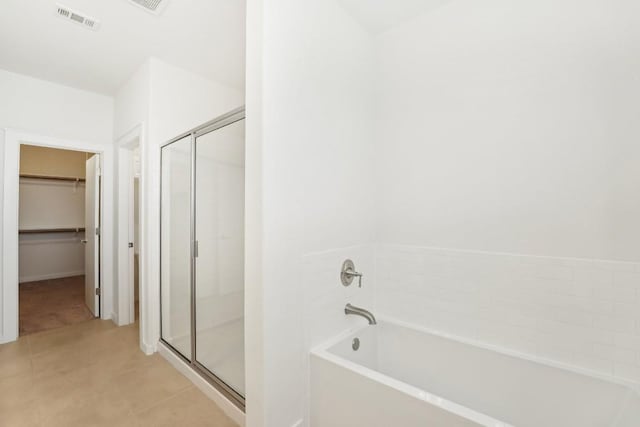 bathroom featuring a stall shower, visible vents, a spacious closet, and a bath