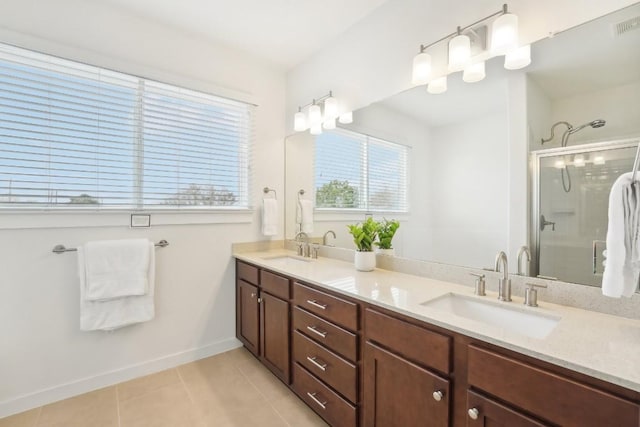 bathroom featuring double vanity, a sink, a shower stall, and tile patterned floors