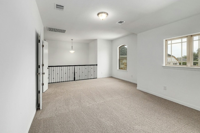 unfurnished room featuring baseboards, visible vents, and carpet floors