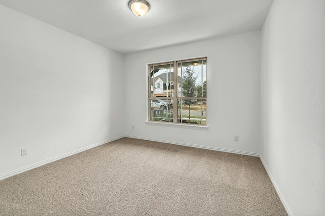 unfurnished room featuring carpet flooring and baseboards