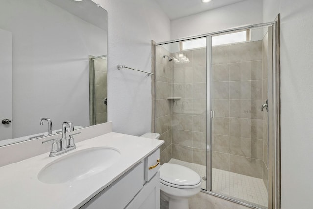 bathroom featuring a stall shower, vanity, and toilet