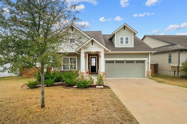 craftsman inspired home with driveway, a shingled roof, a garage, and a front yard