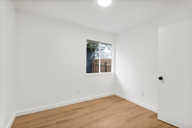 spare room with wood finished floors and baseboards