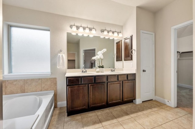 3541 Guadalajara St, Round Rock, TX 78665 - bathroom featuring double vanity, a garden tub, tile patterned flooring, and a spacious closet