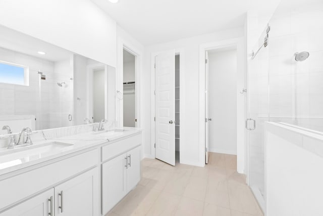 512 Palatino Bnd, Liberty Hill, TX 78642 - full bath featuring a shower stall, a spacious closet, double vanity, tile patterned flooring, and baseboards