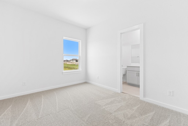 512 Palatino Bnd, Liberty Hill, TX 78642 - unfurnished bedroom featuring light carpet, baseboards, and ensuite bathroom