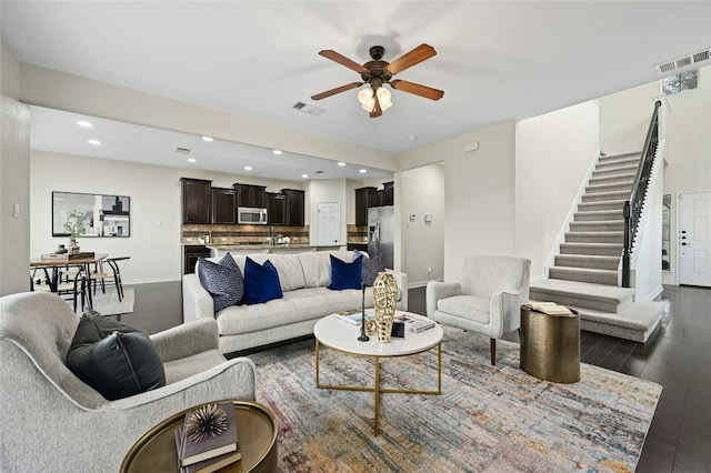 living room with stairway, visible vents, dark wood-style flooring, and recessed lighting