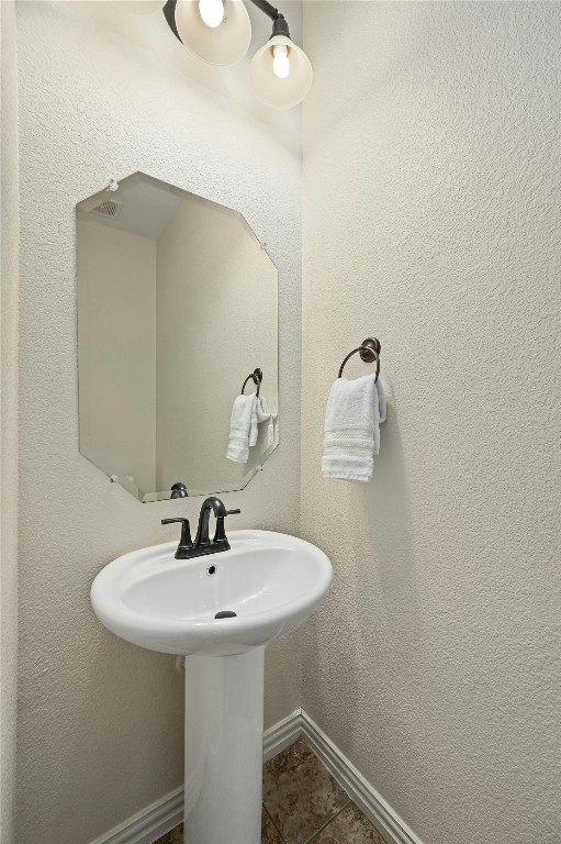 bathroom with baseboards and tile patterned floors