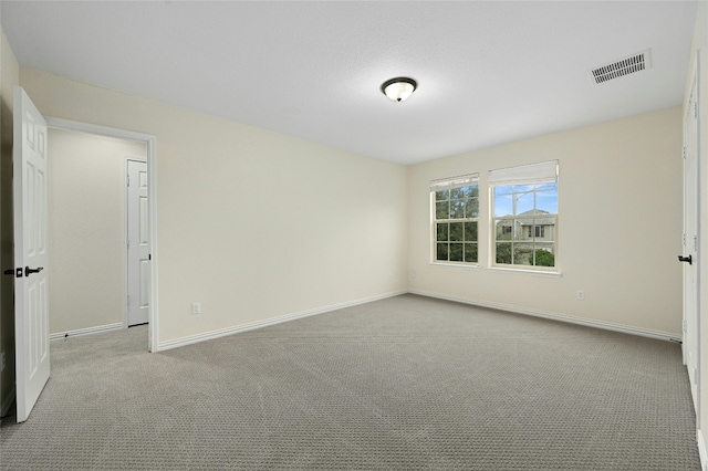 unfurnished bedroom featuring baseboards, visible vents, and light colored carpet