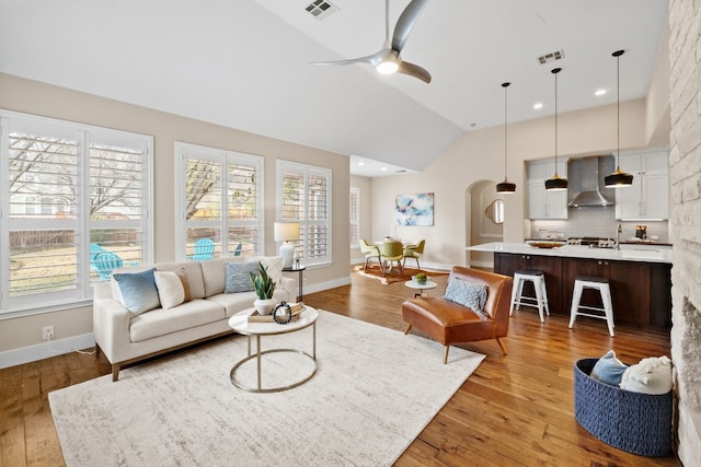 8112 Cobblestone, Austin, TX 78735 - living room with light wood finished floors, baseboards, ceiling fan, arched walkways, and high vaulted ceiling
