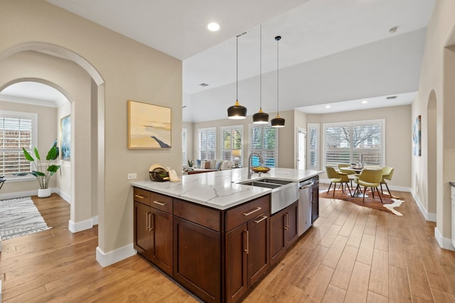 8112 Cobblestone, Austin, TX 78735 - kitchen with a sink, arched walkways, light stone counters, light wood-style floors, and dishwasher