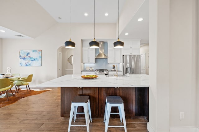 8112 Cobblestone, Austin, TX 78735 - kitchen with stainless steel appliances, wall chimney range hood, a sink, arched walkways, and white cabinets