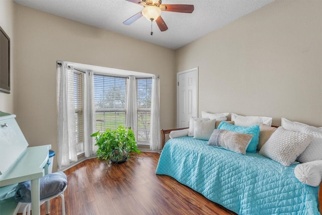 bedroom featuring ceiling fan, a textured ceiling, and wood finished floors