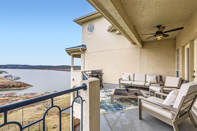 balcony with outdoor lounge area, a water view, and a ceiling fan