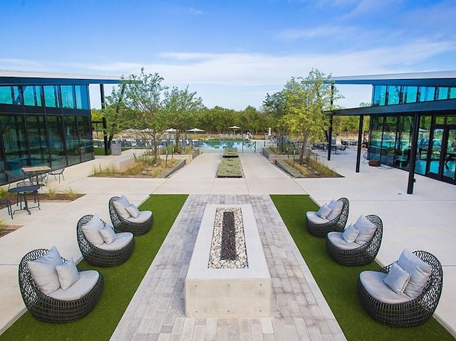 view of community with fence, a fire pit, and a patio