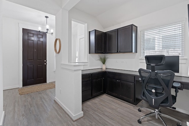 office area featuring light wood-style floors, vaulted ceiling, baseboards, and a chandelier